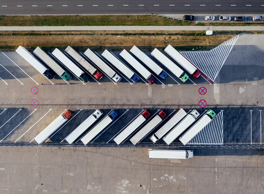 Sorba állított nyerges szerelvények egy kamionparkolóban, madártávlatból